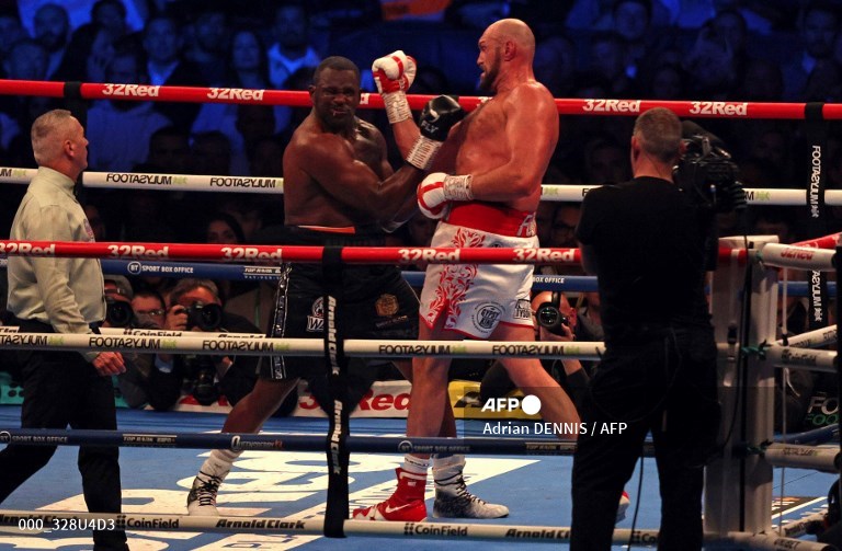 Tyson Fury (kanan) dari Inggris memukul Dillian Whyte dari Inggris di ronde keenam dan memenangkan pertarungan gelar kelas berat WBC di Stadion Wembley di London barat, pada 24 April 2022. Tyson Fury mempertahankan mahkota kelas berat WBC di Wembley yang penuh sesak pada hari Sabtu. Dalam pertarungan pertamanya di tanah Inggris dalam empat tahun, Fury disuguhi sambutan bak pahlawan oleh penonton berkapasitas 94.000 orang.